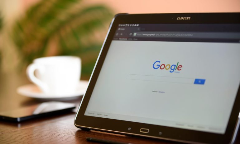 Samsung tablet on desk showing Google homepage, perfect for technology-related content.